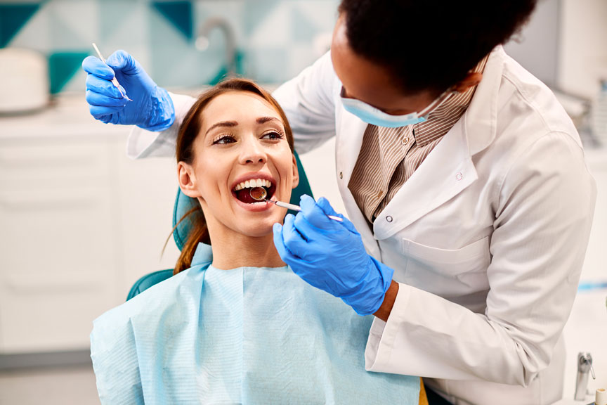 Dentist Examining Female Patient Teeth