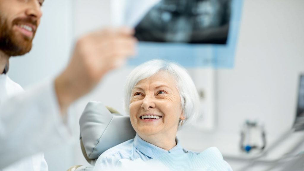 Dentist Showing Dental X-ray To The Patient